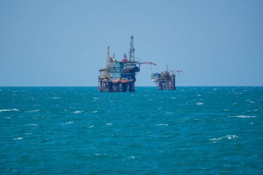 Oil or gas drilling platforms at sea.