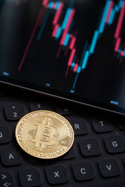 Altın Bitcoin kripto para mum çubuğu grafik şeması, dizüstü bilgisayar klavyesi ve dijital arkaplan.
