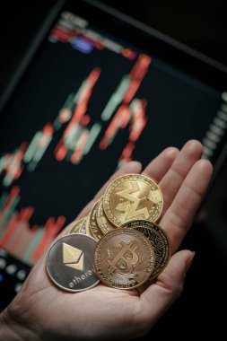 Elinde muhtelif altın kripto paralar, mum çubuğu grafik çizelgesi ve dijital arka planı olan. Bitcoin, Ethereum, Litecoin, dogecoin.