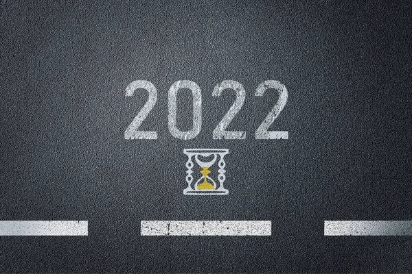 Nuevo año 2022 en la superficie de la carretera de asfalto con icono de cristal de arena. —  Fotos de Stock