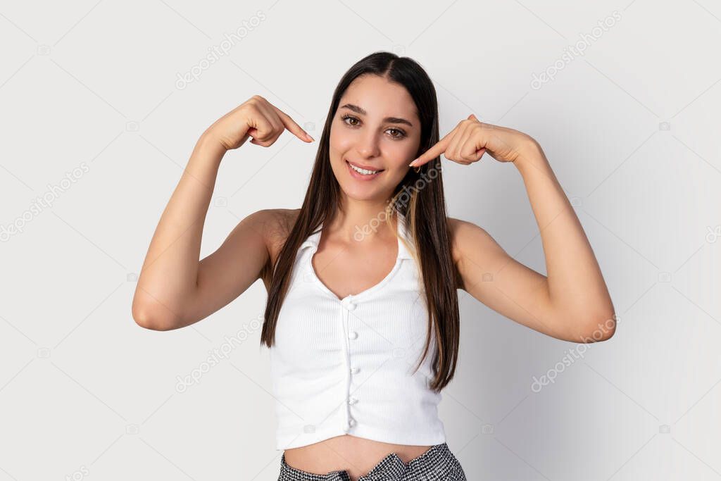 Young brunette woman is pointing her self. A gesture for using as marketing
