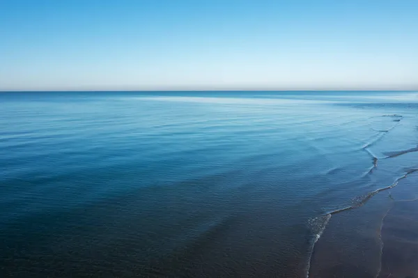 Superficie di primo piano di acqua di mare blu oceano calmo con cielo aperto sulla luce del giorno. Texture astratta di sfondo. — Foto Stock