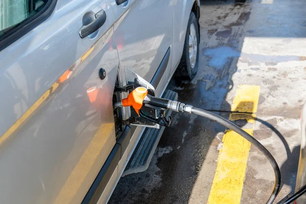 Gaspumpsmunstycke på bilens påfyllningsbränsle till fordonet. Pumpning av bränsle till en bil — Stockfoto