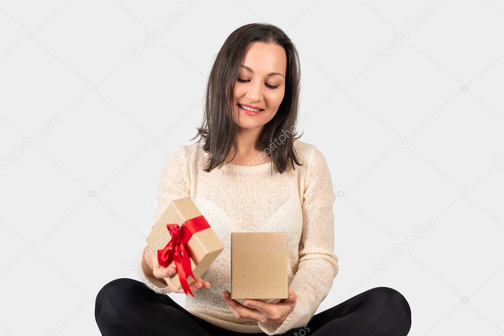 Young woman received a gift box for a special day and opening it with a happy face.