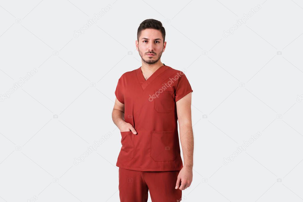 Portrait of a male doctor or nurse wearing burgundy medical uniform.