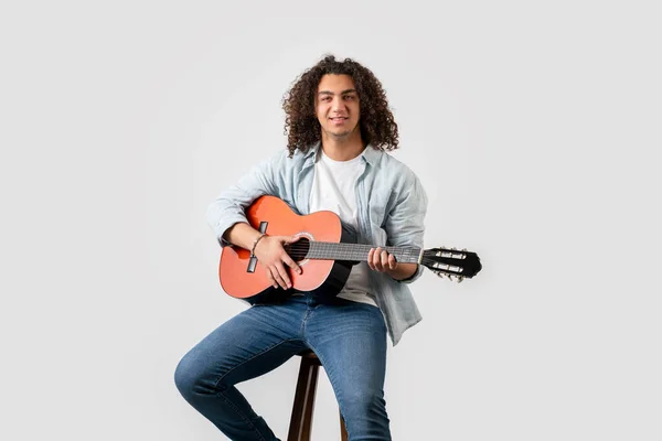 Young man with curly hair, playing acoustic solo guitar, isolated on white background — 스톡 사진