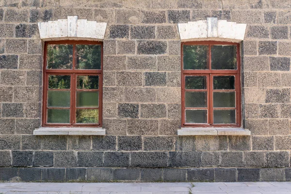 An old classic stone house with windows. Calssic stone walls and windows textures. High quality photo