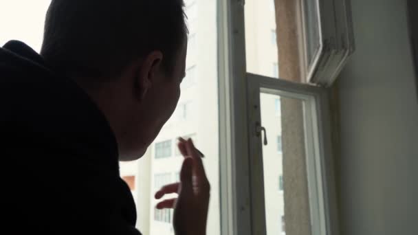 Muž kouří cigaretu sedí u okna 4k záběry — Stock video
