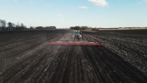 Drone se mueve detrás de una cosechadora que arada el suelo — Vídeos de Stock