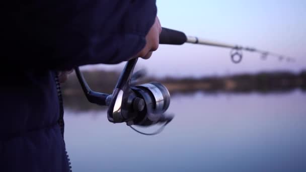 Людина рибалка стоїть на березі річки — стокове відео