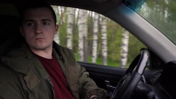 Man rijdt in een auto in het bos — Stockvideo