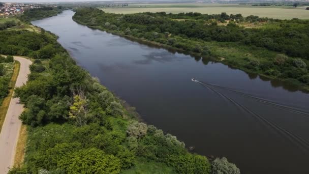 4K drone záběry lodi s lidmi plující podél koryta řeky — Stock video