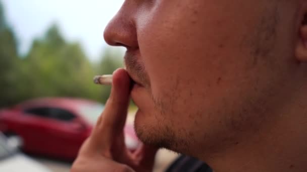 El hombre fuma un cigarrillo en la calle. Imágenes de 4k — Vídeo de stock
