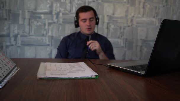 Rozostřený muž mluví video linkou, zatímco sedí ve své kanceláři — Stock video
