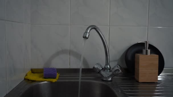 A água derrama da torneira na cozinha — Vídeo de Stock