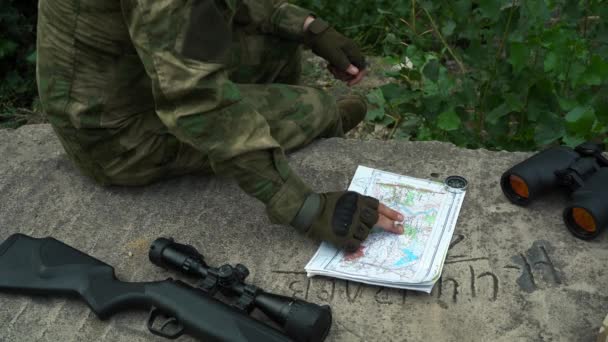 Soldado sentado en una losa de hormigón examina los mapas del movimiento de tropas. Moscú Rusia 20 agosto 2021 — Vídeo de stock