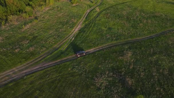 Imágenes de aviones no tripulados 4K detrás de un automóvil en movimiento que conduce por un camino de tierra — Vídeo de stock