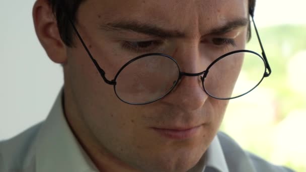 Человек в рубашке выпрямляет круглые очки — стоковое видео