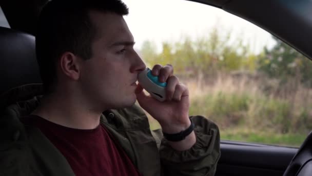 Ένας άντρας φυσάει φάρμακα στη μύτη του ενώ κάθεται σε ένα αυτοκίνητο. — Αρχείο Βίντεο