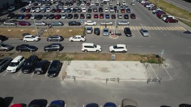 Беспилотник движется над парковкой с большим количеством припаркованных автомобилей — стоковое видео