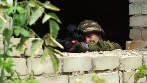 Sniper viser avec un fusil de sniper regardant par la fenêtre. — Video