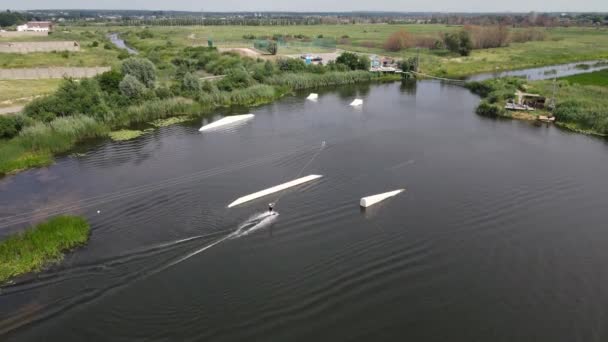 Imágenes aéreas de aviones no tripulados 4k de un hombre montando un wakeboard entre el lago — Vídeos de Stock