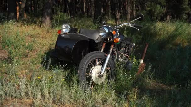 Vieja motocicleta soviética se encuentra en un campo en la hierba — Vídeo de stock