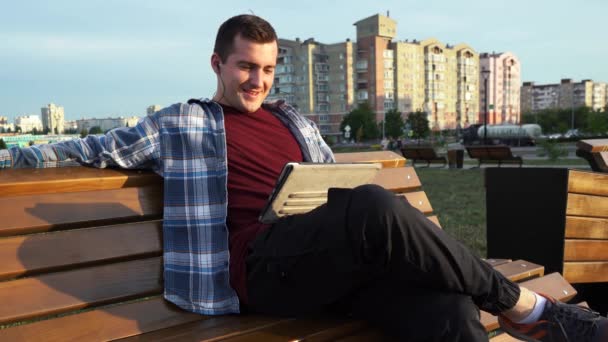 Mężczyzna używa tabletu siedząc na ławce Moskwa Rosja 20 sierpień 2021 — Wideo stockowe