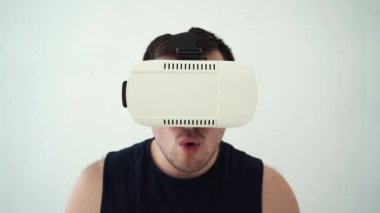 Beyaz arka planda VR gözlüklü traşsız bir adam.
