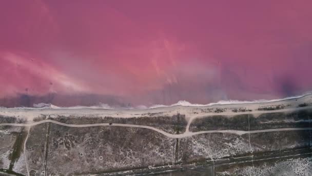 4K footage of a drone flying over the coastline of a pink lake — Stock Video