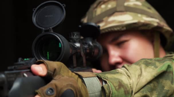 Een man in camouflage richt met een geweer — Stockvideo