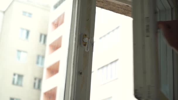 Ein Mann öffnet das Fenster einer Wohnung — Stockvideo
