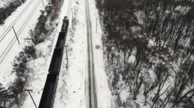 Yük treni kışın demiryolu ile seyahat eder.