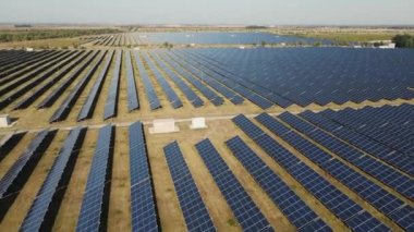 İnsansız hava aracı güneş panelleriyle büyük bir alanın üzerinde uçuyor. 4K görüntü. Güneşten enerji toplamak.