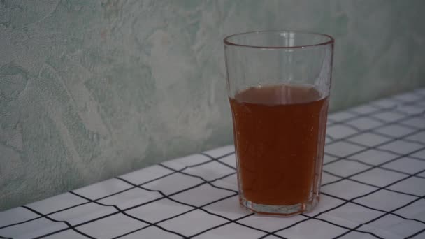 Een glas appelsap ligt op tafel — Stockvideo