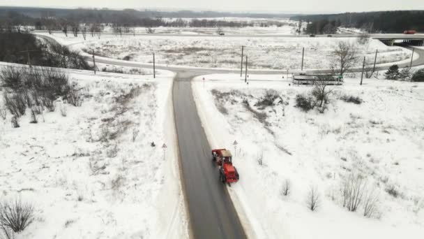 Снегоочиститель очищает снег на трассе зимой — стоковое видео