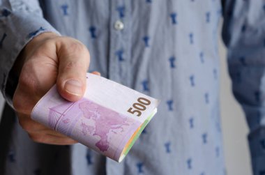 İş adamının elleri avroyu mavi arka planda değiş tokuş ediyor, yakın plan. Avrupa parası. Ekonomik kriz