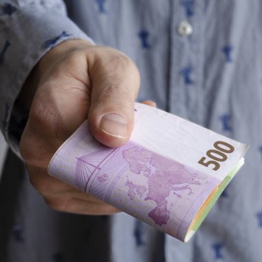 İş adamının elleri avroyu mavi arka planda değiş tokuş ediyor, yakın plan. Avrupa parası. Ekonomik kriz