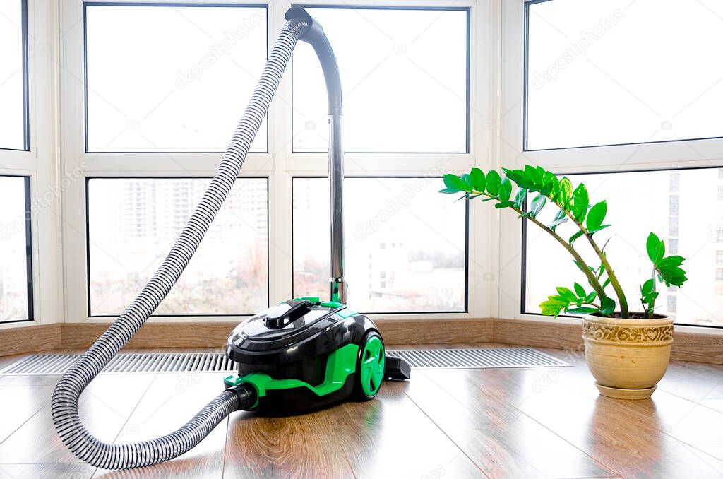 construction cleaning service. Light green vacuum cleaner on a window background
