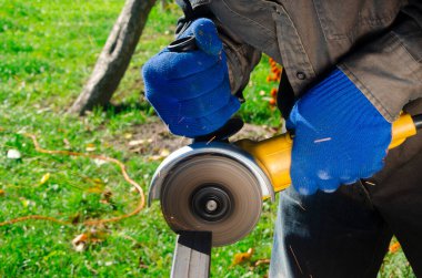 Yakın çekim parlak taraf anında açı kıyma makinesinden kıvılcım. Genç bir erkek kaynakçı bir beyaz eldiven çalışma açısı değirmeni garajda ile metal ürün biler