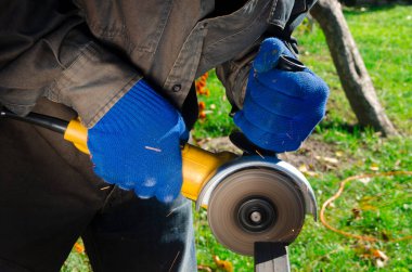 Yakın çekim parlak taraf anında açı kıyma makinesinden kıvılcım. Genç bir erkek kaynakçı bir beyaz eldiven çalışma açısı değirmeni garajda ile metal ürün biler
