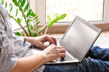 İnternette sörf yapan bir adamın evde dizüstü bilgisayarla çalışmasının düşük açılı görüntüsünü kapatın. Uzaktan kumanda evden çalışıyor. Mesafe öğrenme, izolasyon, iş kavramı