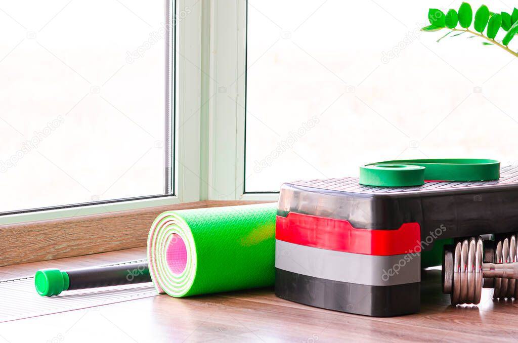 Sports concept. Fitness kit on the floor against the window