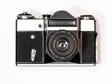 Kahverengi ahşap çerçevede beyaz bir arka planda eski bir kamera var.