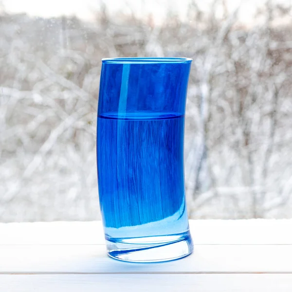 Verre Bleu Déformé Avec Eau Source Claire Sur Fond Une — Photo