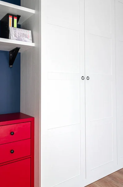 O interior do apartamento no estilo escandinavo. Roupeiro branco, cômoda vermelha e parede azul. Mobília personalizada — Fotografia de Stock