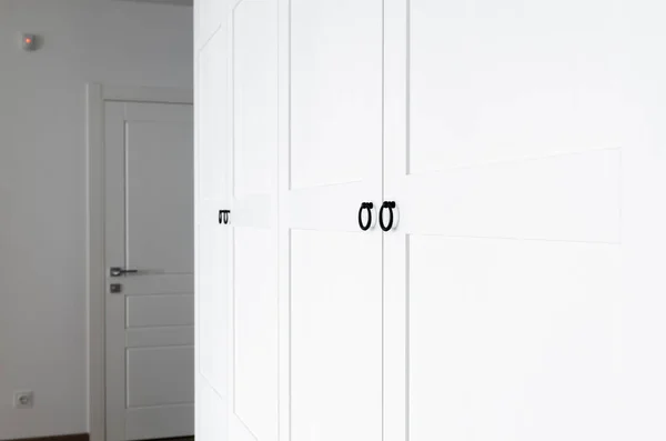 Roupeiro de madeira branco com alças pretas. O interior do apartamento está em estilo escandinavo — Fotografia de Stock