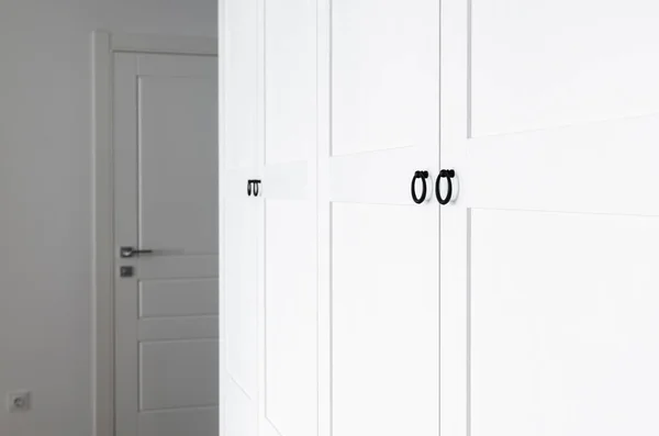 Roupeiro de madeira branco com alças pretas. O interior do apartamento está em estilo escandinavo — Fotografia de Stock