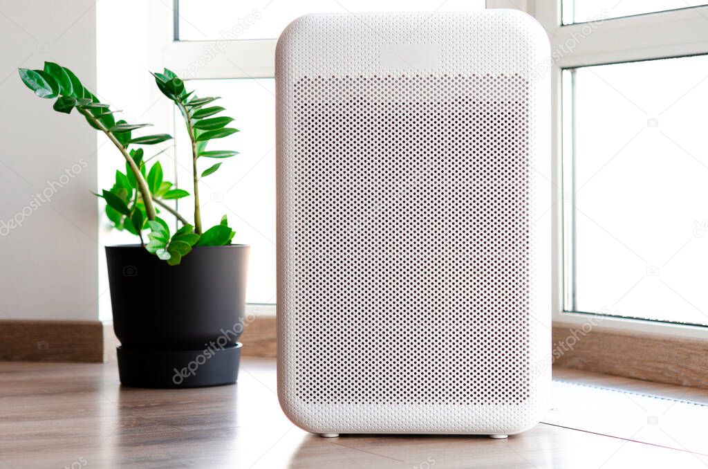 Air purifier in cozy home for filter and cleaning removing dust PM2.5 HEPA and virus in home,for fresh air and healthy Wellness life,Air Pollution Concept