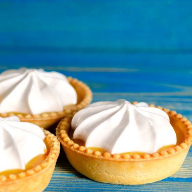 Limonlu turtalar, ev yapımı mini tart kekleri limonlu ve kremşantili, mavi arka plan fotokopi alanı